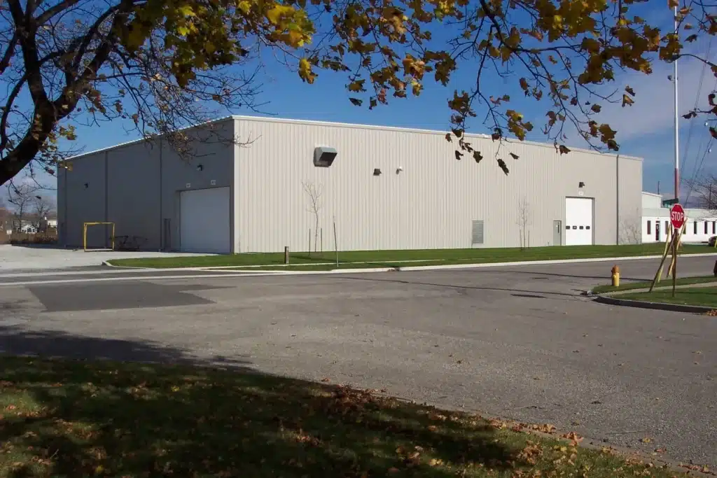 Large gray prefab steel warehouse with roll-up doors.